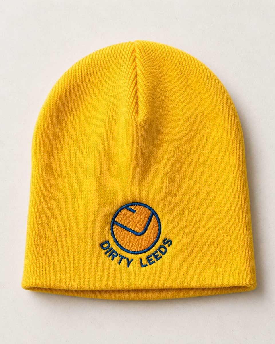 Yellow knitted Dirty Leeds® Smiley Badge Beanie Hat with blue embroidered logo on the front.